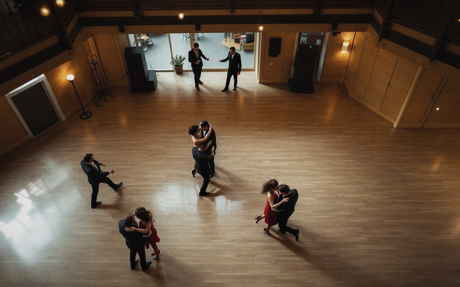 A social dance floor photographed from a balcony, couples distributed across the space